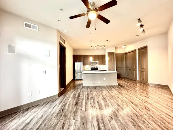 a view of a kitchen with kitchen island a sink stainless steel appliances and cabinets