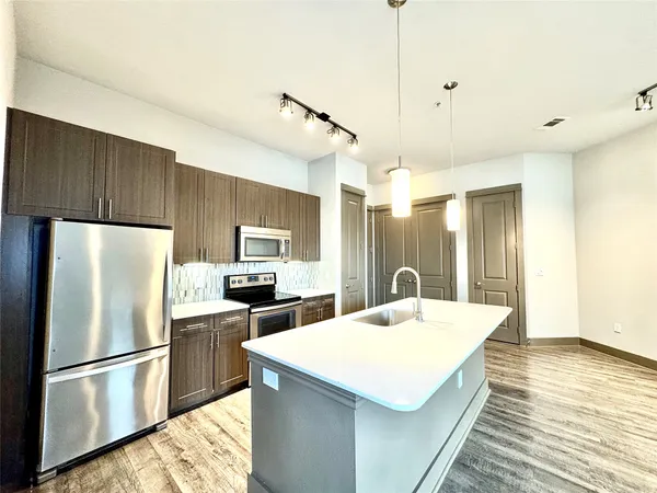 a kitchen with refrigerator and a sink