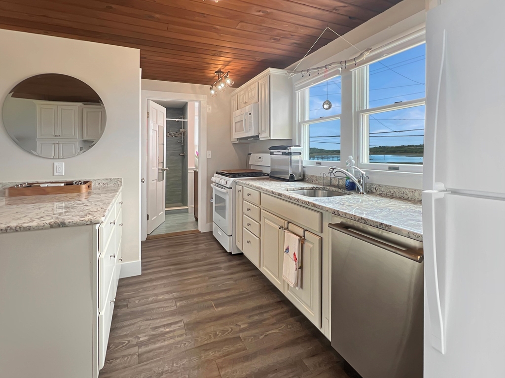 296 Central Avenue Scituate, MA 02050 - Photo 13 of 37 a kitchen with granite countertop a sink and a stove with wooden floor