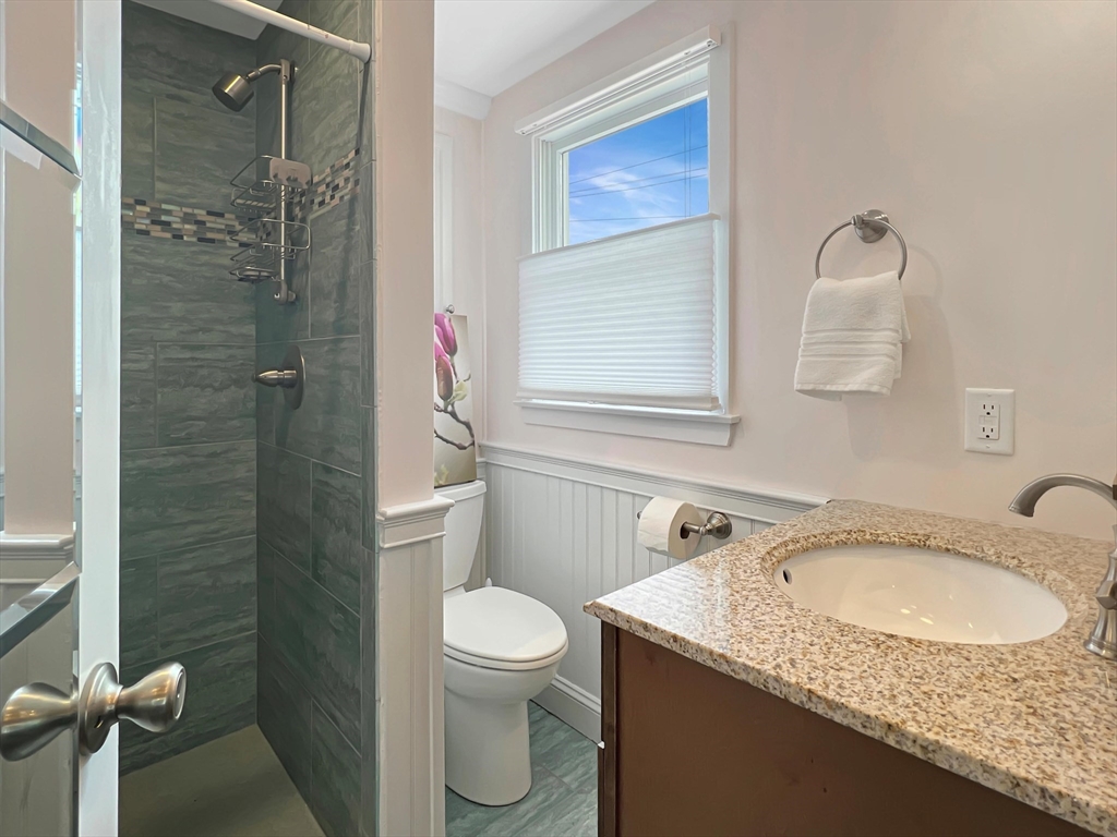 296 Central Avenue Scituate, MA 02050 - Photo 14 of 37 a bathroom with a granite countertop sink a toilet and shower