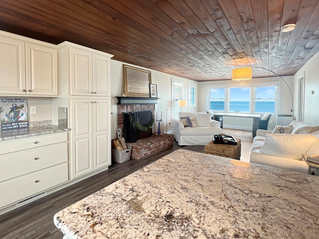 296 Central Avenue Scituate, MA 02050 - Photo 16 of 37 a living room with furniture a fireplace a flat screen tv and a large window