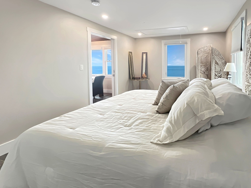 296 Central Avenue Scituate, MA 02050 - Photo 26 of 37 a large bed sitting in a bedroom and a large mirror