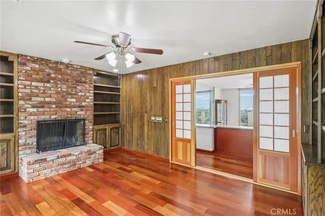 a view of a livingroom with a chandelier fan and windows