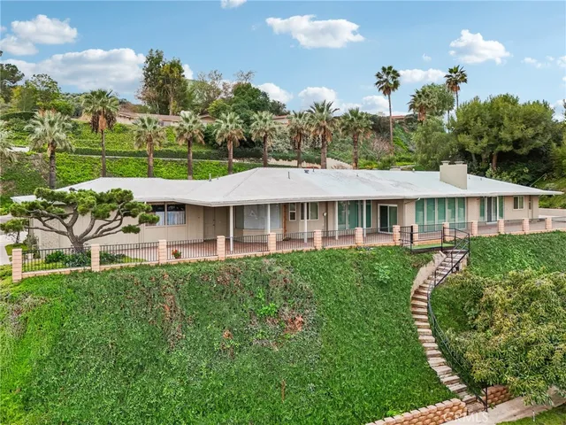 a view of a house with pool and sitting area