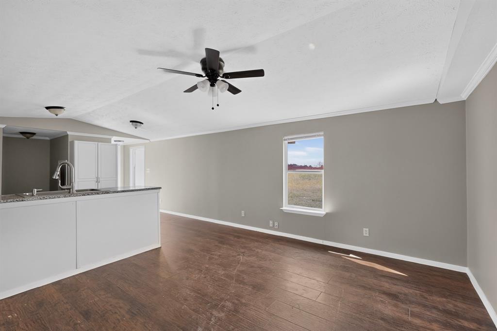 15281 Stice Road Krum, TX 76249 - Photo 6 of 22 Open-concept living space featuring wood-finish flooring, a contemporary ceiling fan, and crown molding