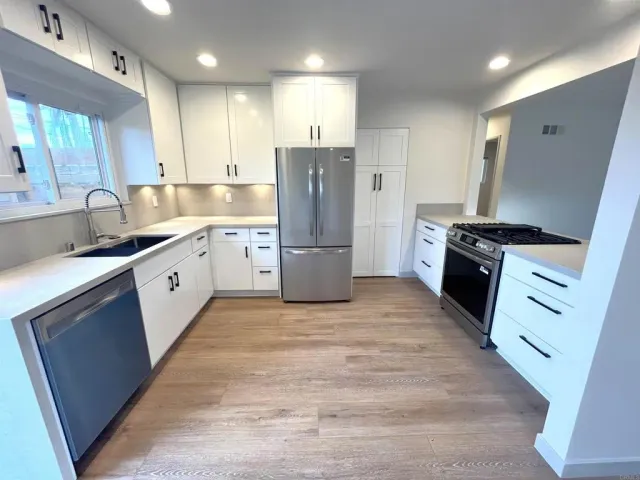 a kitchen with a refrigerator stove and wooden cabinets