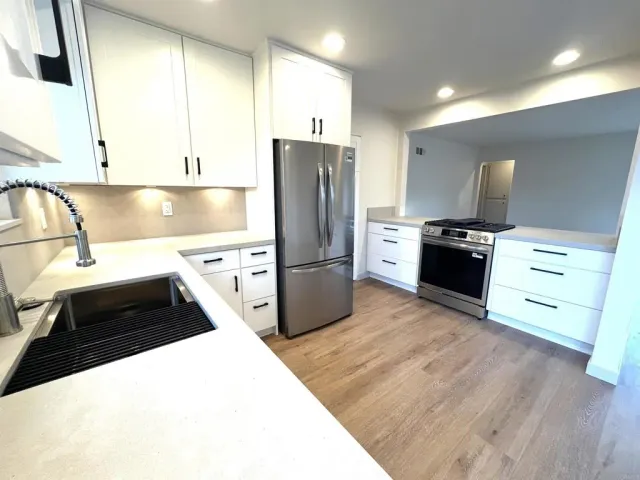 a kitchen with stainless steel appliances granite countertop a stove a sink and a refrigerator