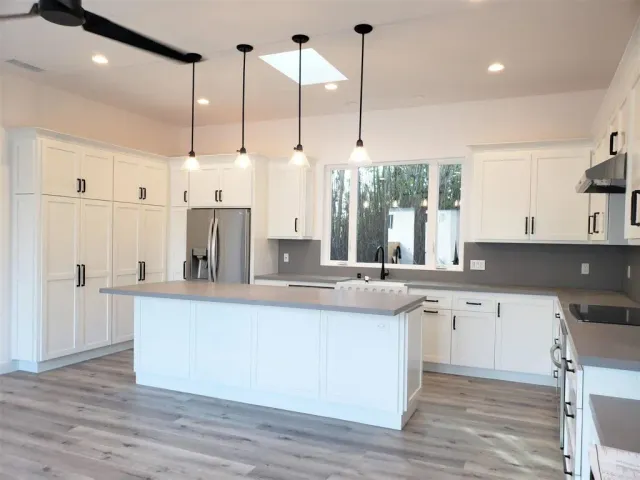 a kitchen with a sink a refrigerator and cabinets