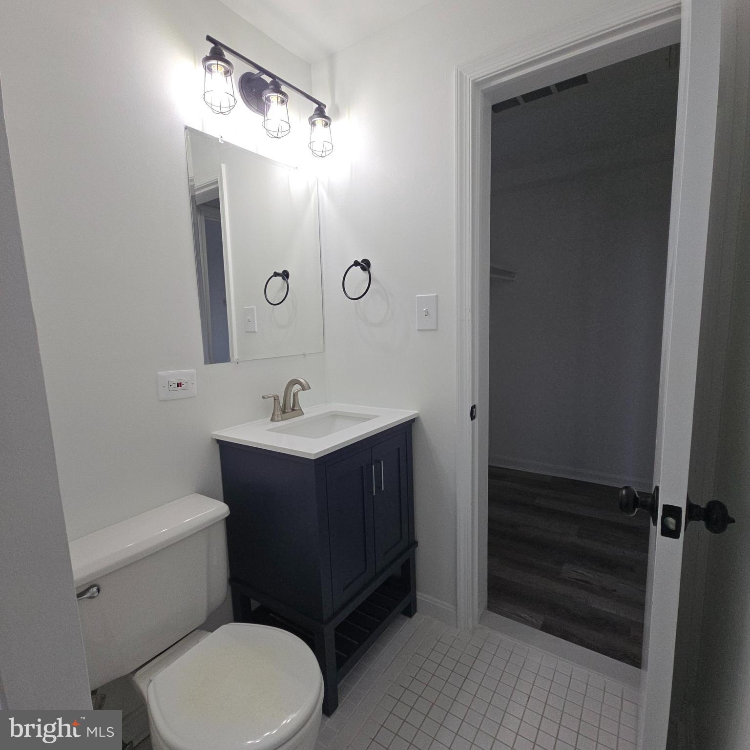 1451 Park Road Northwest, Unit 419 Washington, DC 20010 - Photo 12 of 17 a bathroom with a toilet a sink and mirror