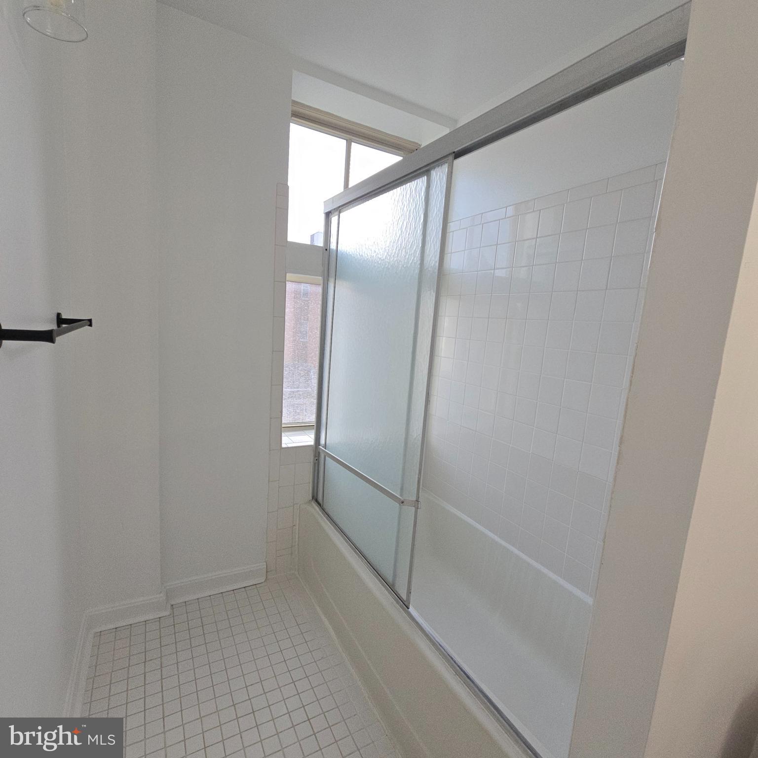 1451 Park Road Northwest, Unit 419 Washington, DC 20010 - Photo 14 of 17 a bathroom with a glass shower door