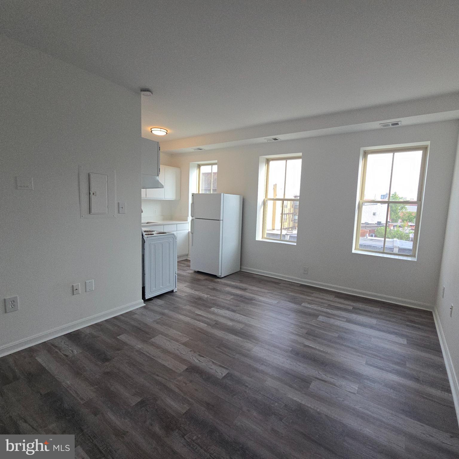 1451 Park Road Northwest, Unit 419 Washington, DC 20010 - Photo 5 of 17 an empty room with wooden floor and windows