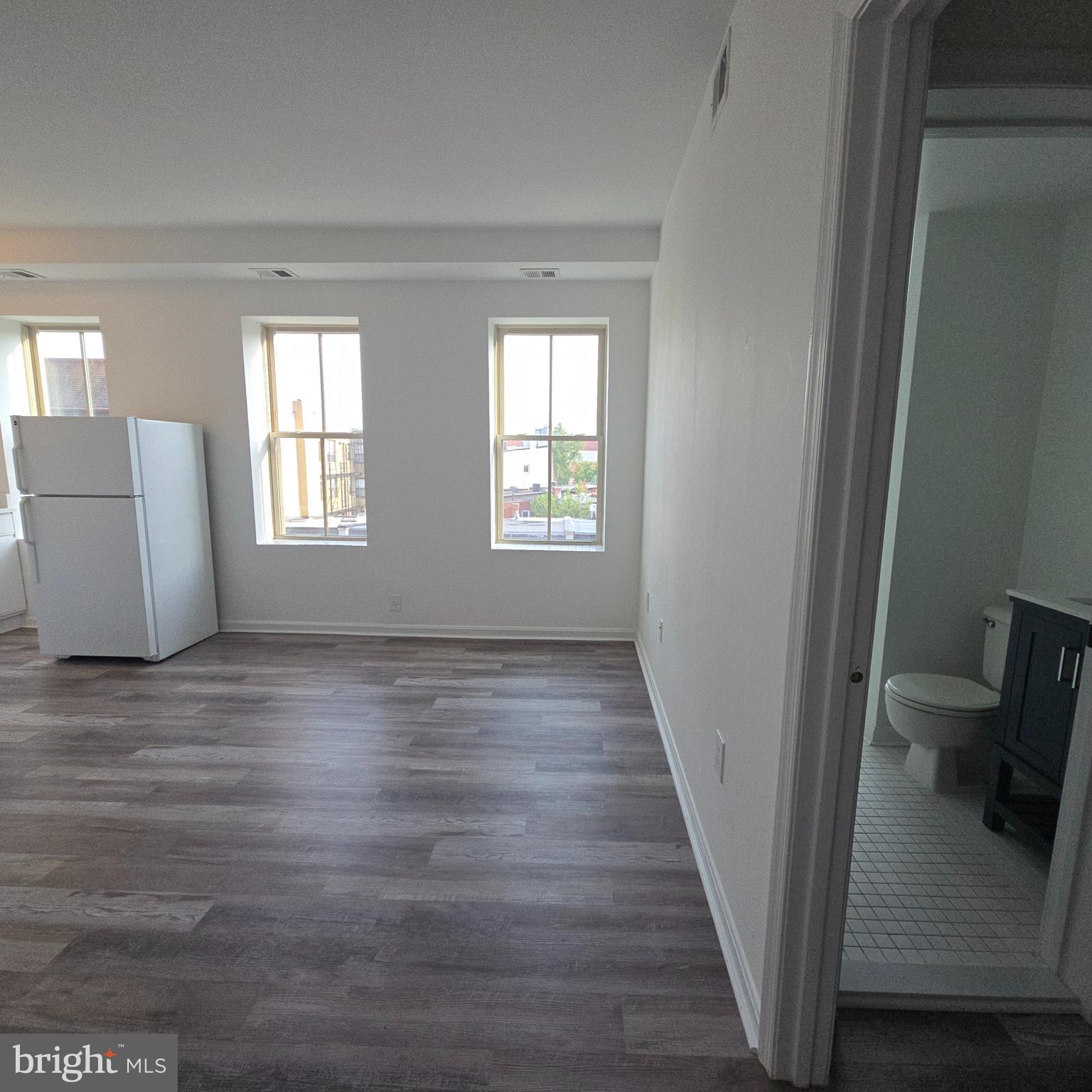 1451 Park Road Northwest, Unit 419 Washington, DC 20010 - Photo 8 of 17 a view of an empty room with a window and wooden floor