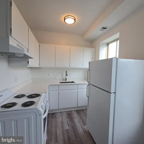 a kitchen with granite countertop white cabinets and white stove