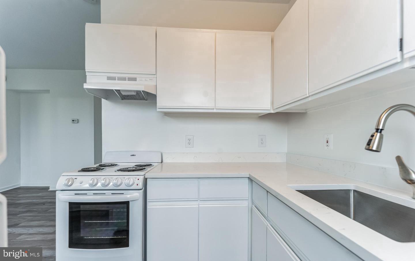 1451 Park Road Northwest, Unit 419 Washington, DC 20010 - Photo 10 of 17 a kitchen with granite countertop white cabinets and white stove