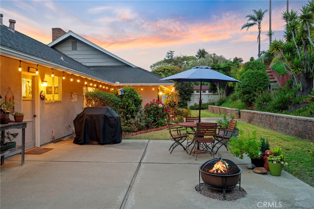 3495 Ridgecrest Drive Carlsbad, CA 92008 - Photo 5 of 42 a view of a patio with table and chairs under an umbrella with a fire pit