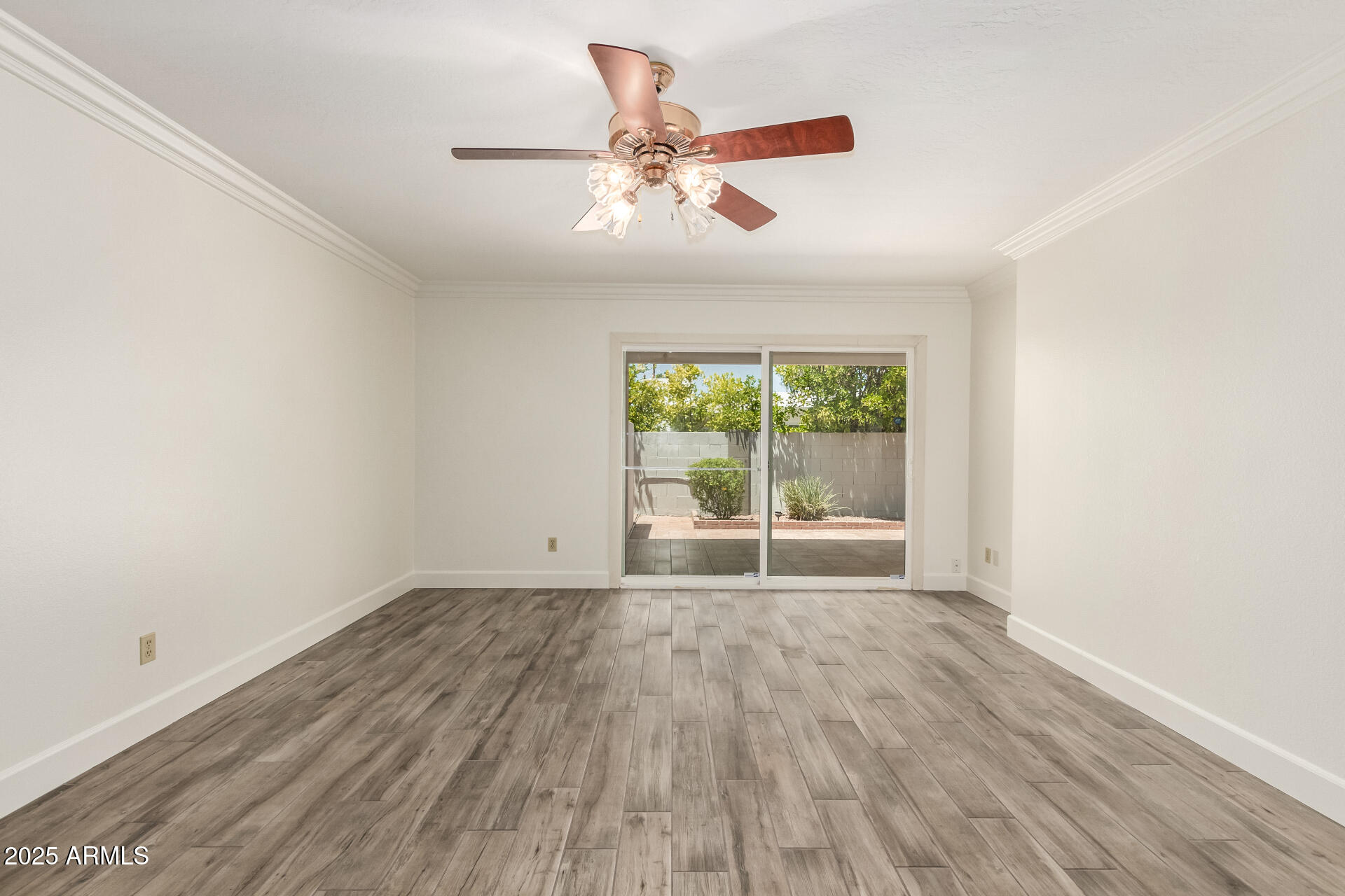 38 East Calavar Road Phoenix, AZ 85022 - Photo 25 of 45 an empty room with wooden floor chandelier fan and windows