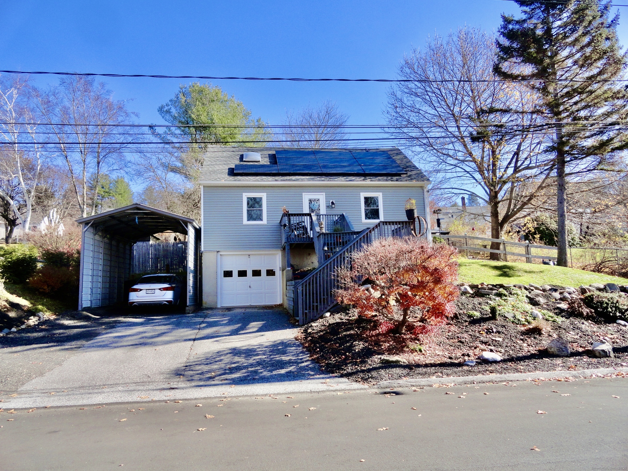 a front view of a house with a yard outdoor seating and covered with trees