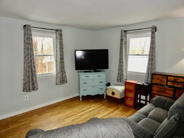 a bedroom with furniture and a flat screen tv