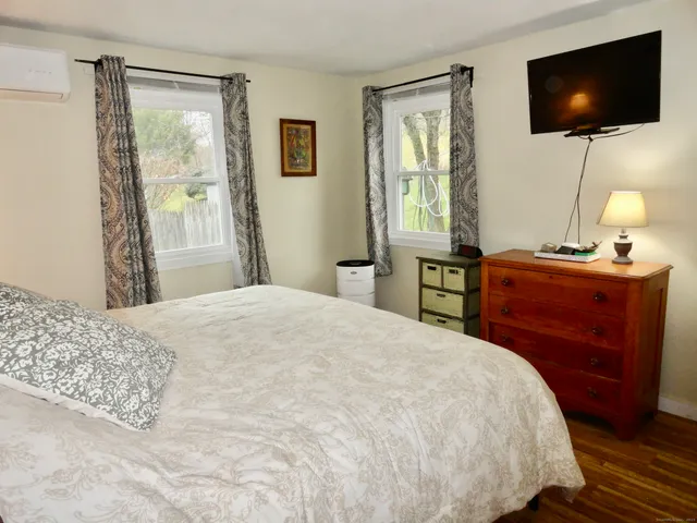 a bedroom with a flat screen tv and a bed