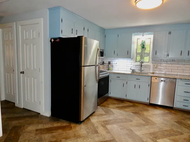 a kitchen with a refrigerator sink and cabinets