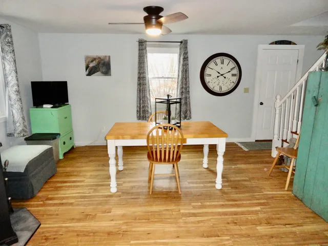 a living room with furniture a clock and a flat screen tv