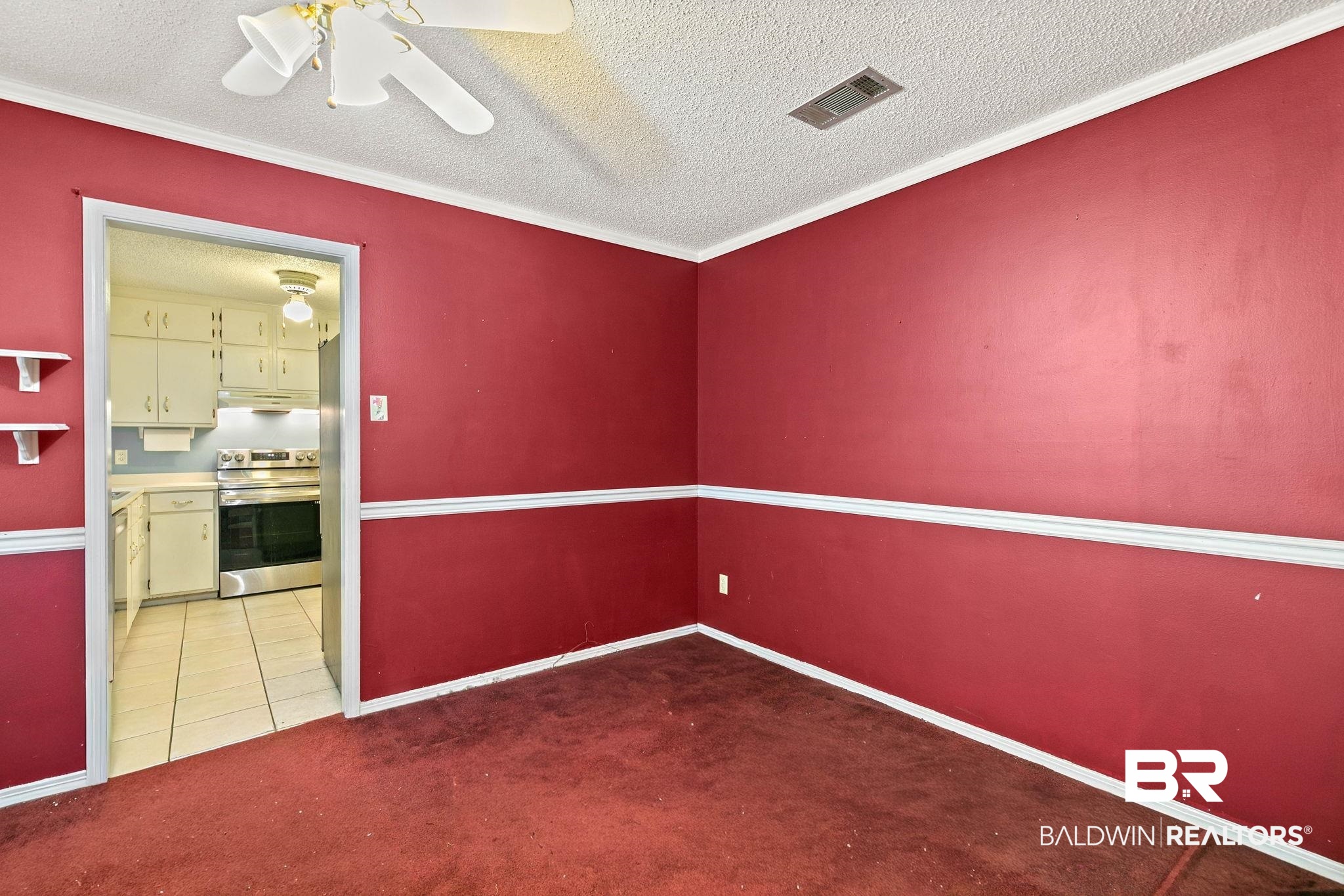 13653 Roberts Road Loxley, AL 36551 - Photo 7 of 33 Interior room featuring red walls with white chair rail molding, a white ceiling fan, and red carpet flooring