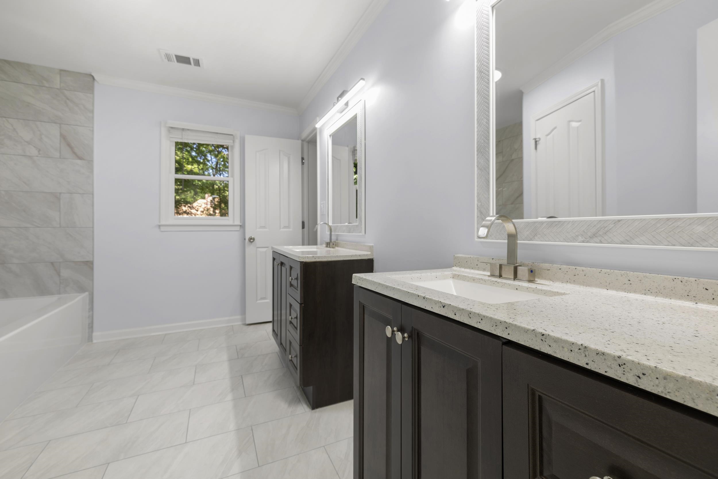 486 Brook Ridge Circle Memphis, TN 38018 - Photo 36 of 40 Bathroom with two vanities, crown molding, a tub to relax in, and light tile patterned flooring