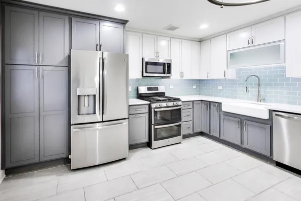 a kitchen with stainless steel appliances a stove a sink and a refrigerator