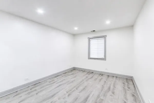 an empty room with wooden floor and a window