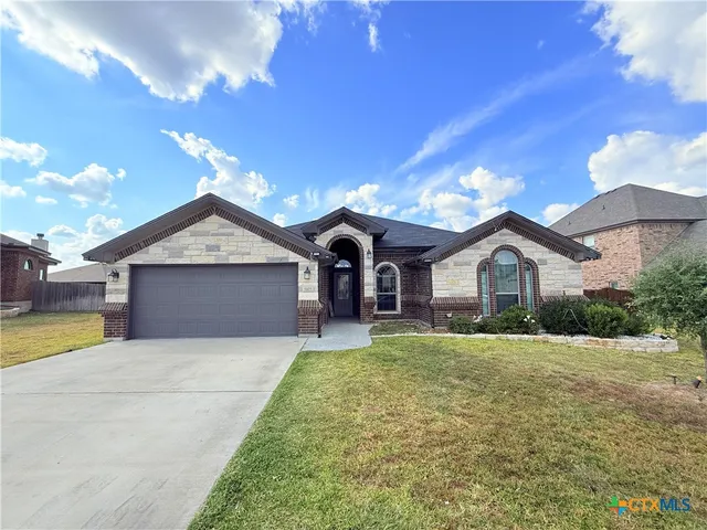 a front view of a house with a yard and garage