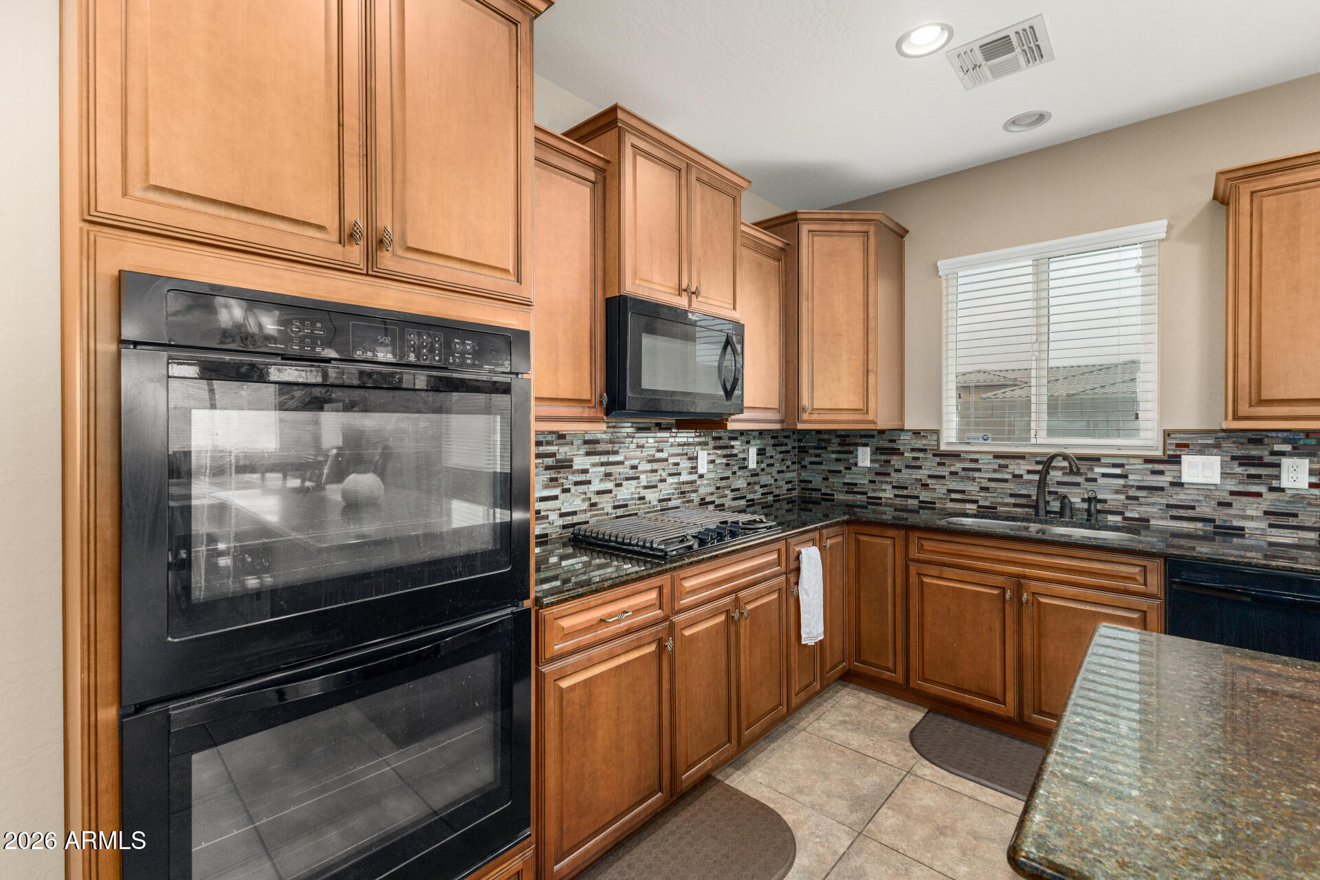 5718 West Pecan Road Laveen, AZ 85339 - Photo 13 of 37 a kitchen with stainless steel appliances granite countertop a stove microwave and sink