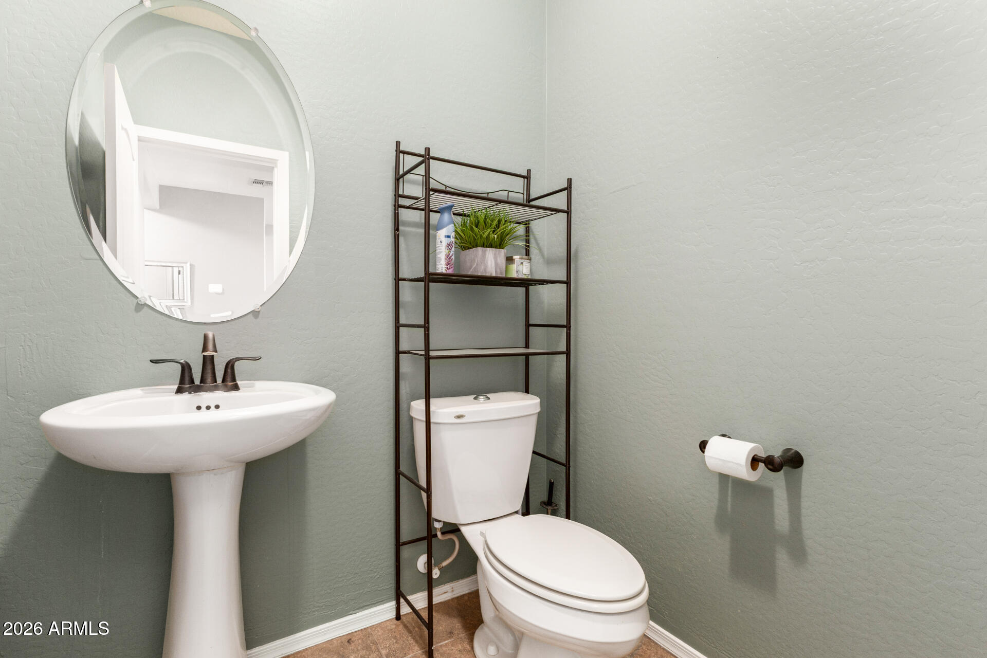 5718 West Pecan Road Laveen, AZ 85339 - Photo 16 of 37 a white toilet sitting next to a bathroom sink