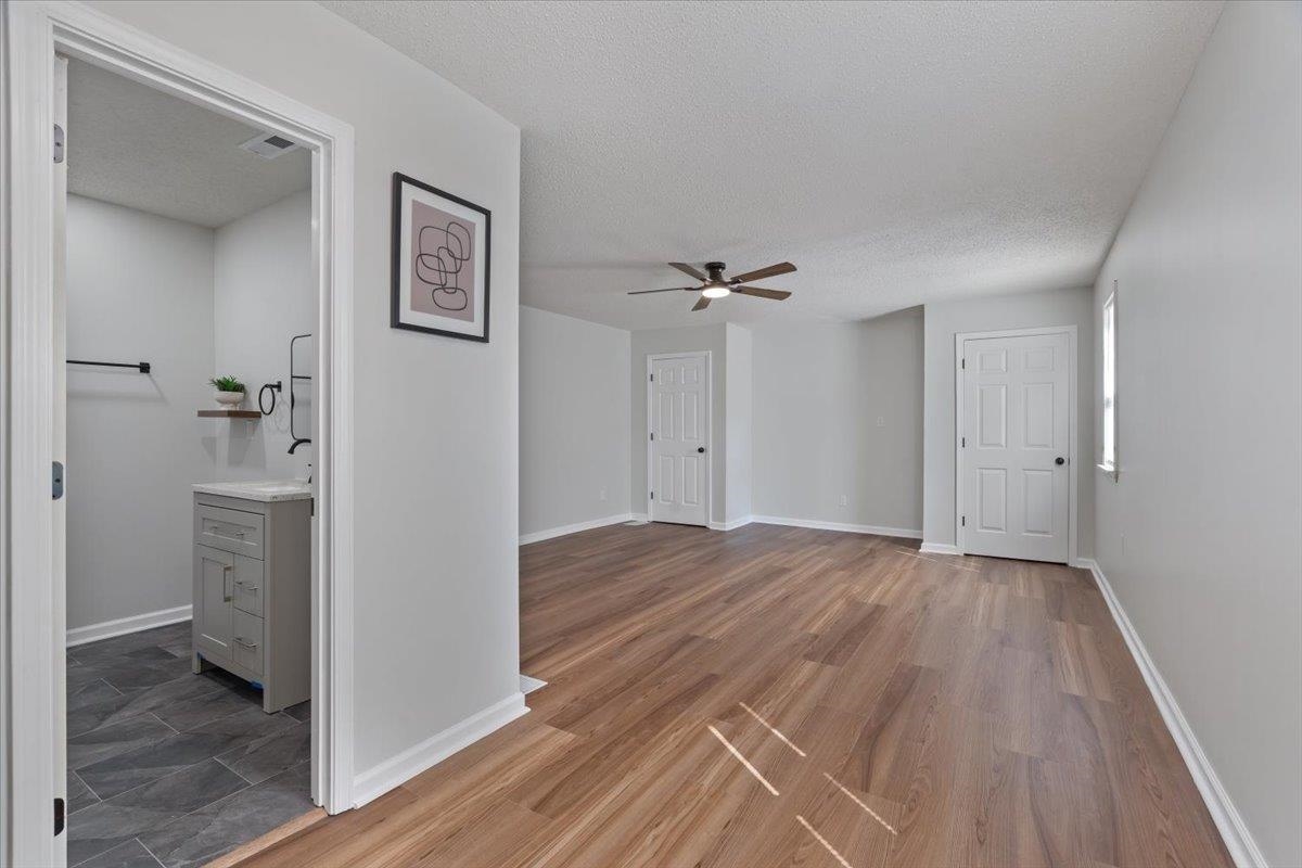 524 McDermitt Road Memphis, TN 38120 - Photo 19 of 32 Wood-finish flooring, ceiling fan, white paneled doors, and light gray walls