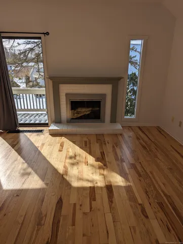 a view of empty room with wooden floor and fireplace
