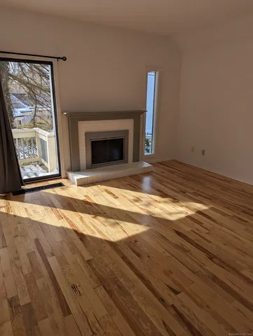 a view of empty room with wooden floor and fireplace