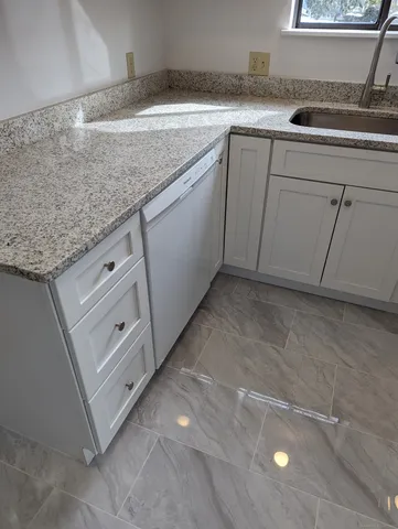 a utility room with granite countertop cabinets washer and dryer