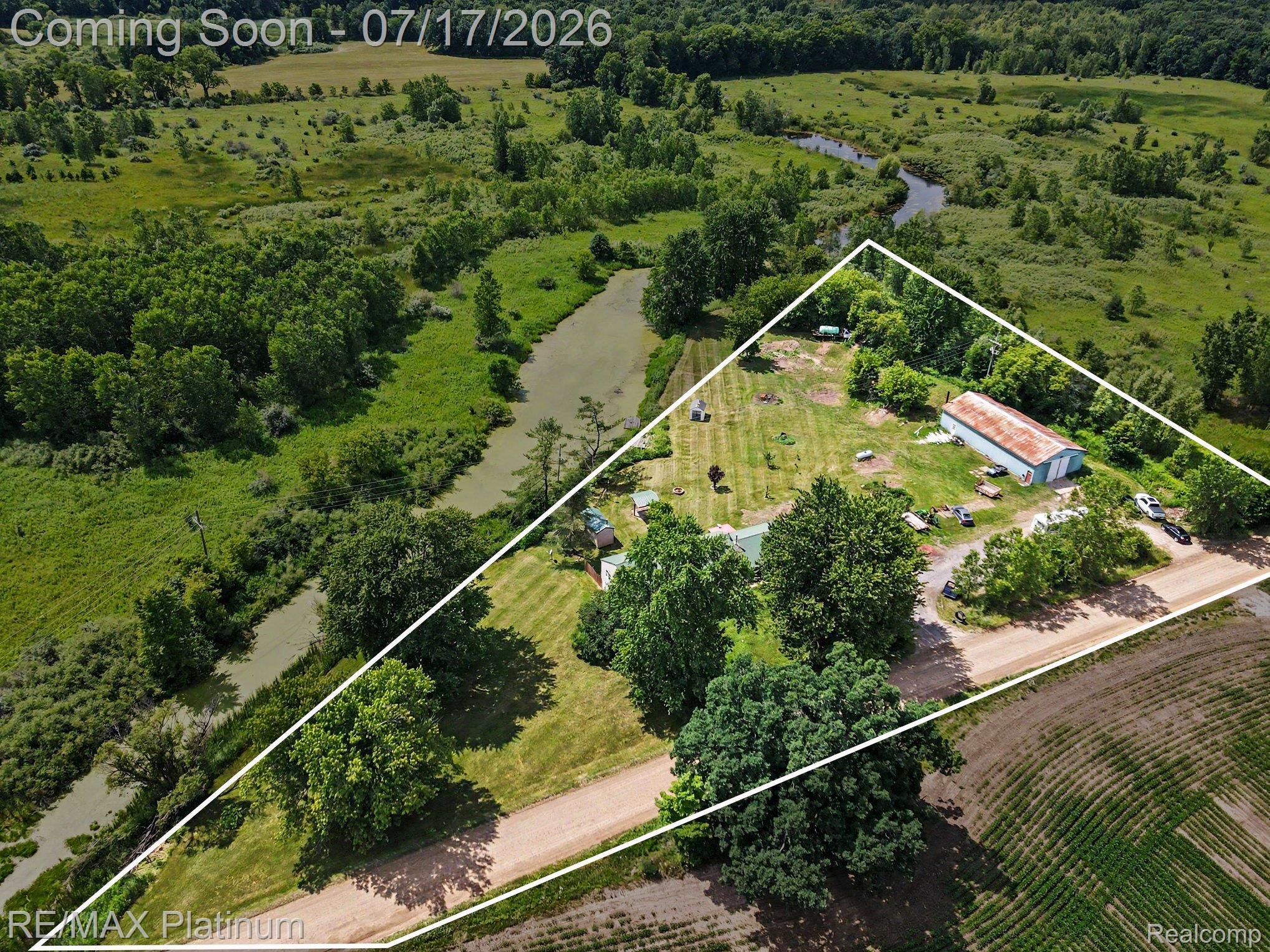 4205 Musson Road Howell, MI 48855 - Photo 21 of 23 Expansive property featuring a large metal outbuilding, gravel driveway, and mature trees
