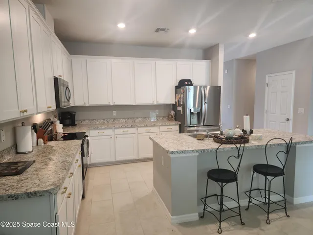 a kitchen with granite countertop sink cabinets and stainless steel appliances