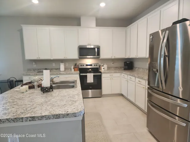 a kitchen with stainless steel appliances granite countertop a sink refrigerator and stove