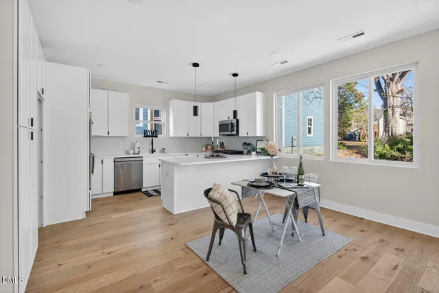 a view of a white house with large windows next to a road