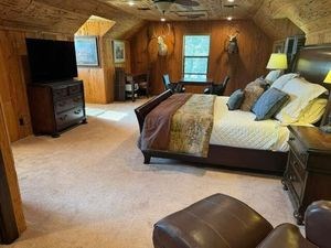 215 70l Rd Junction Junction, TX 76849 - Photo 12 of 43 a spacious bedroom with a bed a mirror on dresser and a flat screen tv