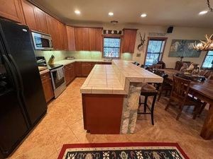 215 70l Rd Junction Junction, TX 76849 - Photo 7 of 43 a kitchen with stainless steel appliances granite countertop a table chairs sink refrigerator and microwave