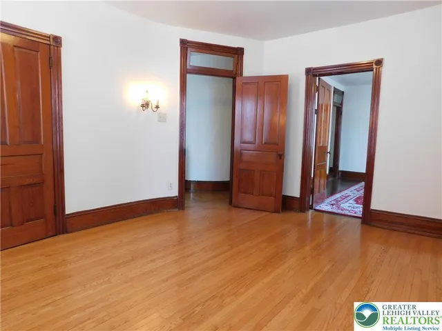 an empty room with wooden floor and closet