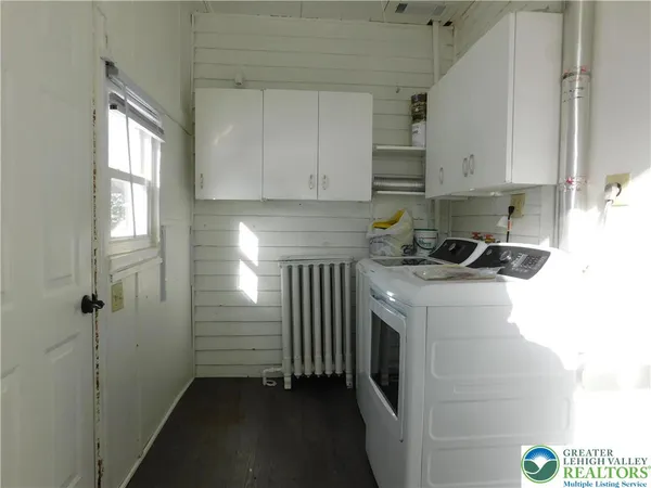 a kitchen with a refrigerator and white cabinets