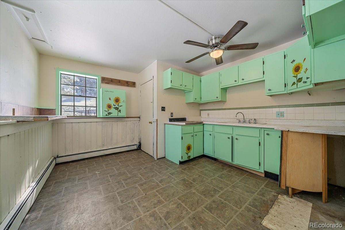 4551 Hilltop Road Evergreen, CO 80439 - Photo 14 of 30 a kitchen with window cabinets and window