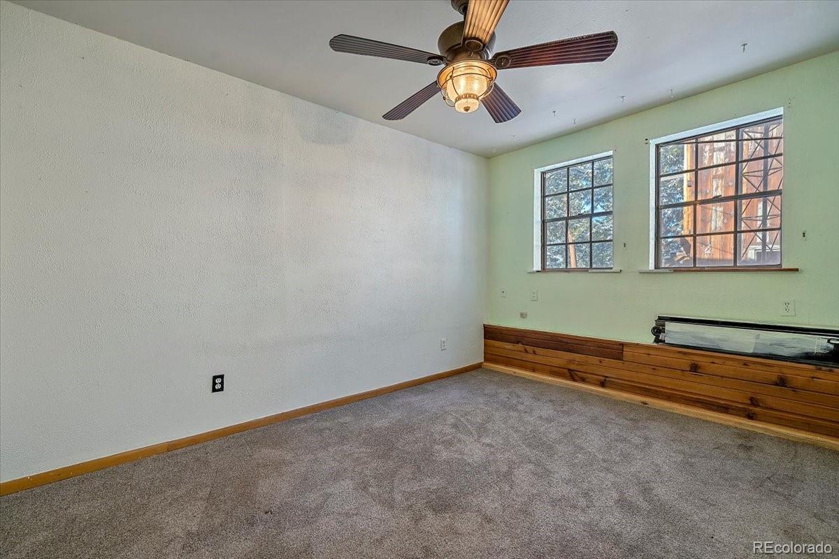 4551 Hilltop Road Evergreen, CO 80439 - Photo 17 of 30 an empty room with windows and ceiling fan