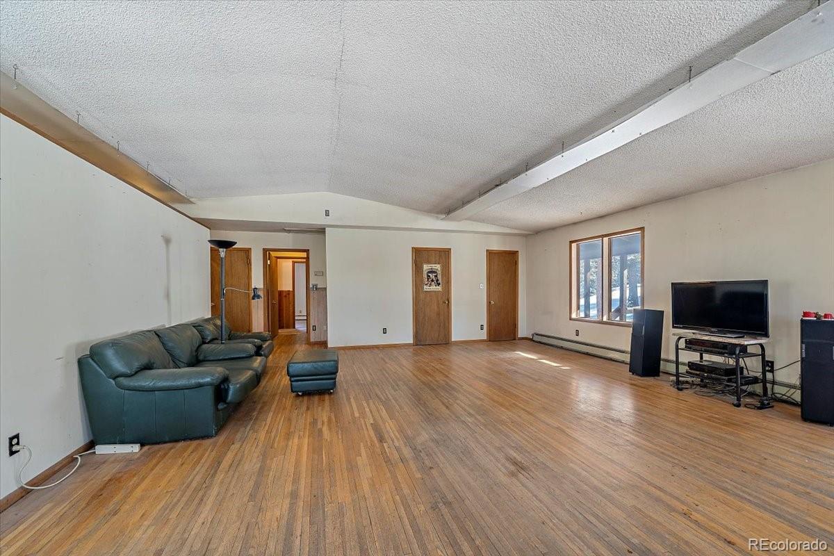 4551 Hilltop Road Evergreen, CO 80439 - Photo 3 of 30 a living room with furniture and a flat screen tv