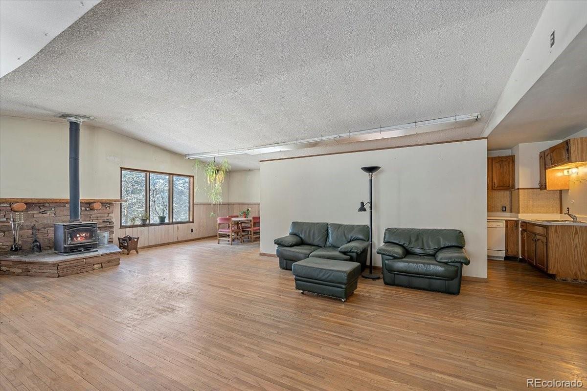 4551 Hilltop Road Evergreen, CO 80439 - Photo 4 of 30 a living room with furniture and a wooden floor