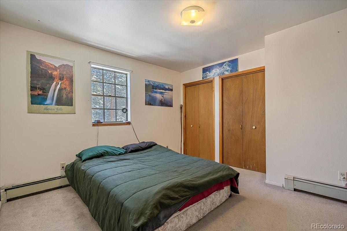 4551 Hilltop Road Evergreen, CO 80439 - Photo 9 of 30 a bedroom with a bed and a window