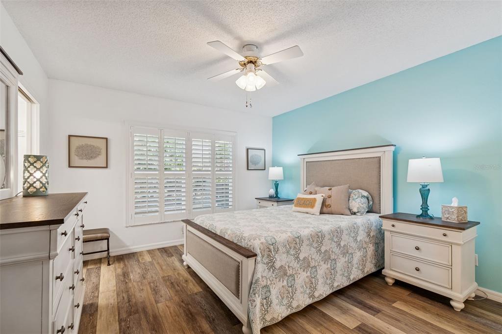 2291 Americus Boulevard West, Unit 3 Clearwater, FL 33763 - Photo 22 of 88 a bedroom with a bed and a dresser with wooden floor